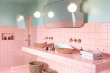 bright pink tiles paired with light blues, with gold fixtures and black grout for a bold look