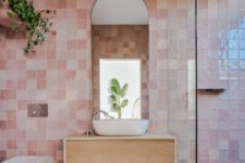 cool pink glazed tiles, white appliances and a floating wooden vanity plus some greenery