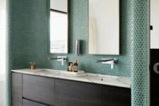 emerald penny tiles covering the sink zone highlight it and make a statement for a chic modern look