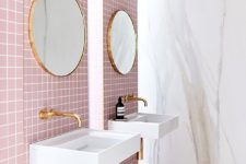 pink tiles and neutral marble slab walls plus gold fixtures make a cool contemporary bathroom with a touch of luxury