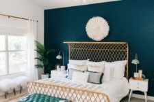 03 a catchy boho bedroom with a wicker bed, a turquoise leather bench, a gold chandelier and faux fur stools