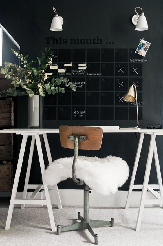 a moody Scandinavian home office with a chalkboard wall and a calendar for a whole month