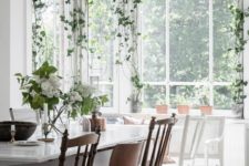 10 a light-filled dining room with several climbing plants that make the space feel outdoor