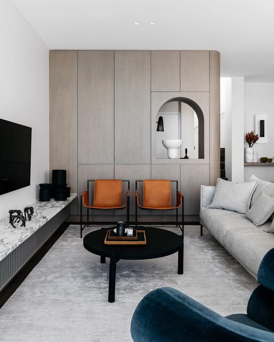 a modern luxurious living room with amber leather chairs that add texture and color to the space