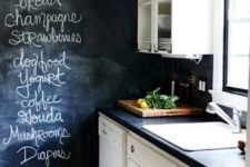 11 a monochromatic contrasting kitchen with a chalkboard wall and backsplash for noting food and drinks to buy