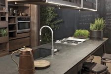 13 a large wood and metal industrial kitchen with a chalkboard wall with recipes is a cool space with much greenery