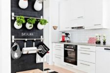 23 a Scandinavian kitchen in a monochromatic color scheme, with a chalkboard herb wall with railings
