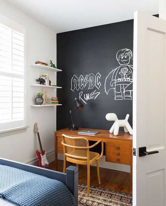 a small yet inviting kid's bedroom with a chalkboard wall and stylish furniture is a very cool space for the little owner