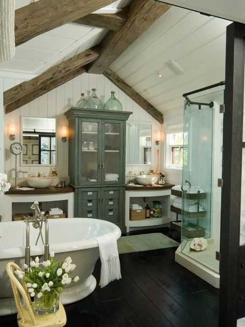 a beautiful neutral farmhouse bathroom with lots of furniture, a shower space, a vintage-inspired tub and wooden beams on the ceiling