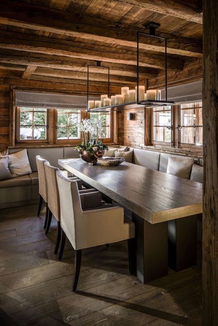 a cozy chalet dining space with a corner sofa, a wooden table, some modern chairs, a pendant candle holder is welcoming