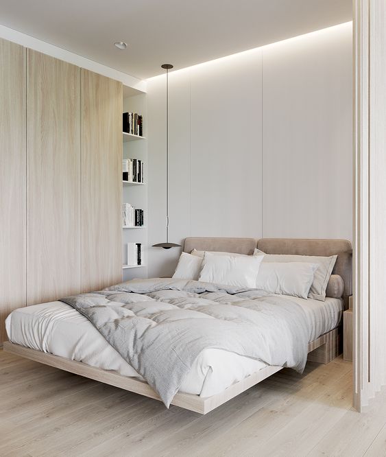 a cozy minimalist bedroom with a raised bed with an upholstered headboard, a sleek storage unit and pendant lamps
