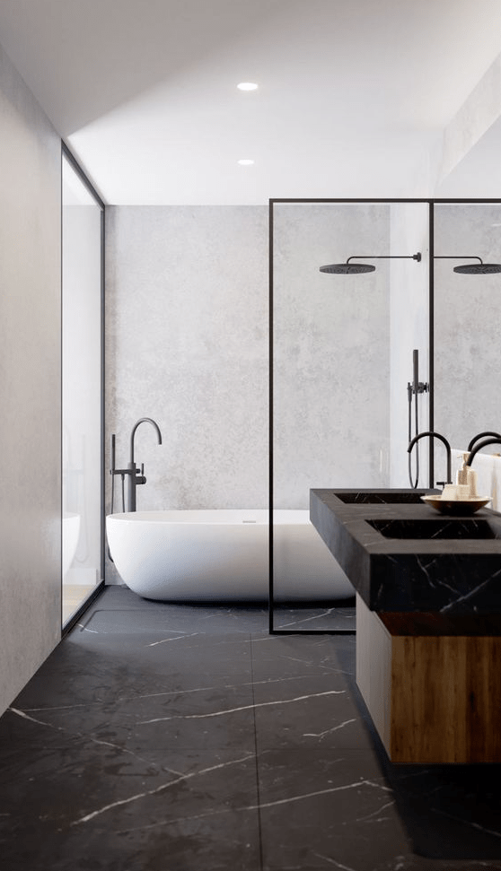 a luxurious minimalist bathroom with a black marble floor and sinks, a wooden vanity and black fixtures that echo with the marble