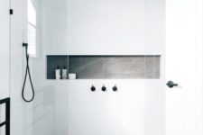 a minimalist bathroom with grey tiles on the floor, white tiles on the walls, black fixtures for a more catchy look