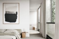 a minimalist bedroom in neutrals with an upholstered bed, wooden nightstands, a statement artwork and a large window