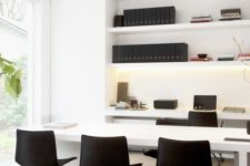 a minimalist black and white home office with open shelves, a desk and a meeting table with black chairs