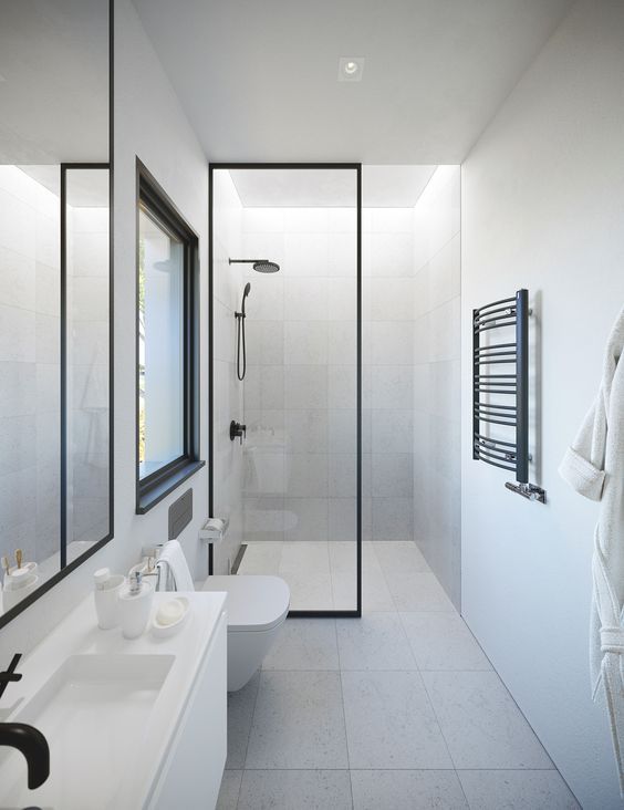 a minimalist neutral bathroom with tiles, a white vanity, a mirror, a window and a shower space plus black touches for drama