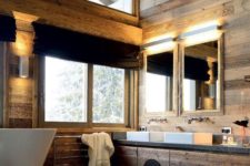a modern chalet bathroom clad with light-colored wood, with touches of black, modern furniture and appliances