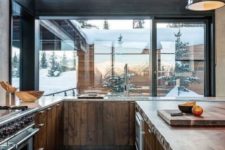 a modern chalet kitchen with glazed walls, wooden cabinets and a kitchen island, built-in lights and appliances