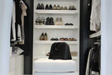 a monochromatic minimalist closet with open shelves, holders for hangers, white sideboards and lots of built-in lights