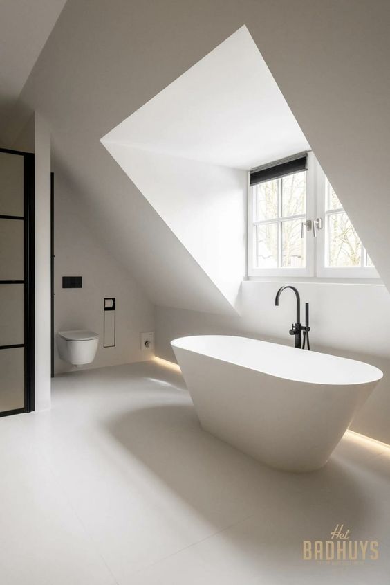 a serene minimalist attic bathroom with a window, a shower with black frames, a tub by the window and a floating toilet