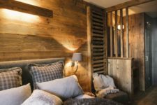 a simple and modern chalet bedroom with light-stained wood everywhere, lots of faux fur and cozy textiles