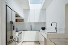 a sleek white minimalist kitchen with elegant cabinets, white countertops, a long skylight and a wooden kitchen island