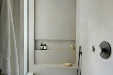 a small minimalist bathroom with marble tiles, concrete walls, black fixtures and a frosted glass window