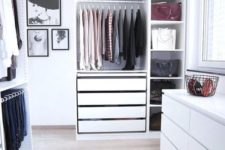a small minimalist white closet with a dresser, drawers, open shelves and holders and hangers is very neat