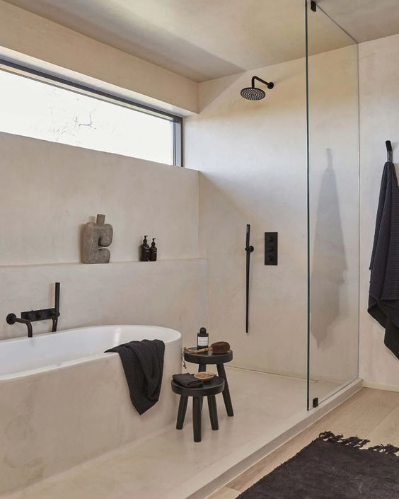 a warm-colored minimalist bathroom with a clerestory window, a tub, a shelf, a shower and some black items for a touch of drama