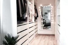 a white minimalist closet with drawers, open storage compartments and shelves plus lights and lamps