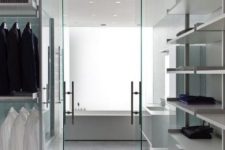 an ultra-minimalist white closet with holders for hangers, open shelves and some dressers
