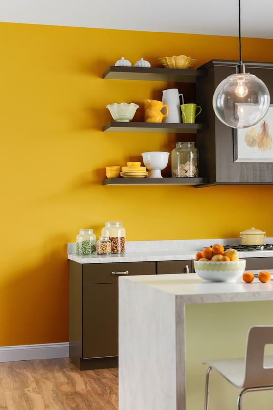 a sunny yellow accent wall brightens up a brown and neutral kitchen and makes it bold and cool