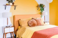 08 a bright and cheerful bedroom with a yellow wall and a yellow circle on the wall plus bright bedding is welcoming