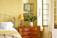 10 a bright country style bedroom with yellow brick walls, a yellow lamp and bedding