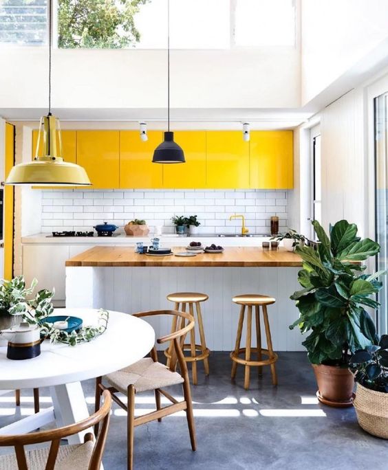 a contemporary white kitchen with sunny yellow upper cabinets that make it feel outdoorsy and bright
