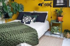 16 a cozy attic bedroom with a mustard accent wall and lots of potted greenery plus green, black and white bedding