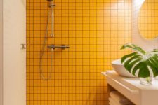 17 a minimalist bathroom clad with white tiles, with wooden beams on the ceiling and a sunny yellow tile wall