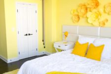 18 a colorful bedroom with lemon yellow walls, floral appliques on the wall and bright bedding