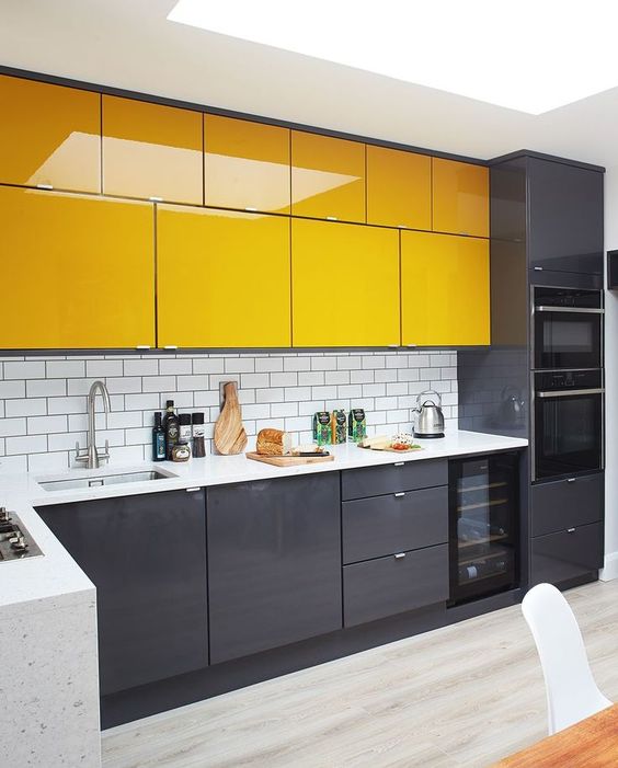 a modern kitchen in graphite grey and yellow, with a white subway tile backsplash and a white stone countertop