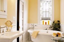 20 a beautiful pastel yellow bathroom with a crystal chandelier, vintage appliances and fixtures plus lamps