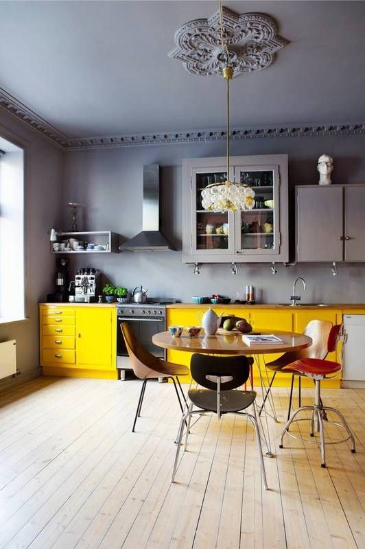 a moody grey kitchen with sunny yellow lower cabinets that brighten up and light up the whole space
