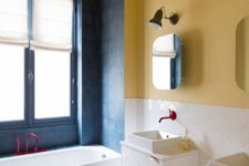 21 a bright bathroom with a yellow wall and a yellow and white tile floor, a blue bathtub zone and white tiles