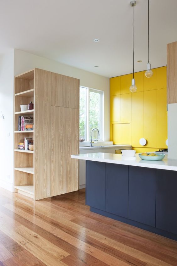a stylish minimalist kitchen done in white, yellow and navy, with no handles looks bright and bold
