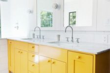 24 a serene white bathroom with white subway tiles and a yellow vanity plus yellow and white mosaic tiles