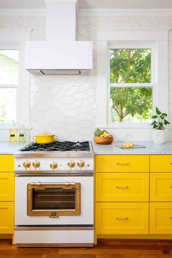 a vivacious yellow kitchen with white tiles and neutral stone countertops brings a fresh and airy feel