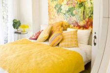 26 a vivacious bedroom with an oversized floral artwork that takes a whole wall and matching yellow bedding and pillows