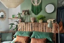 a bold and chic boho bedroom with a green accent wall, a green macrame hanging, green chair and bedding plus touches of wood looks lovely