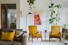 a bright boho living room with mustard chairs and pillows, potted greenery, a vibrant rug and comfy furniture