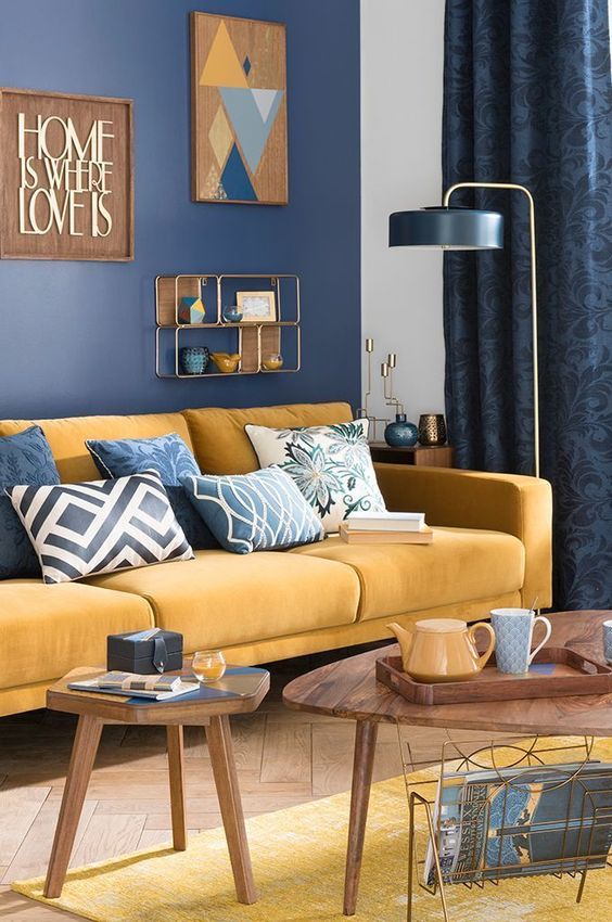 a bright navy and yellow living room with plenty of pattern, comfortable modern furniture and touches of wood