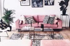 a catchy monochromatic living room with pink furniture and potted plants plus a chic gallery wall
